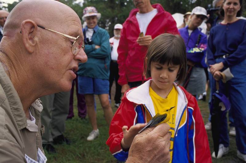 FWS Volunteer Holds Prothonatary Warbler for Young Girl at Bird Banding Event.jpg